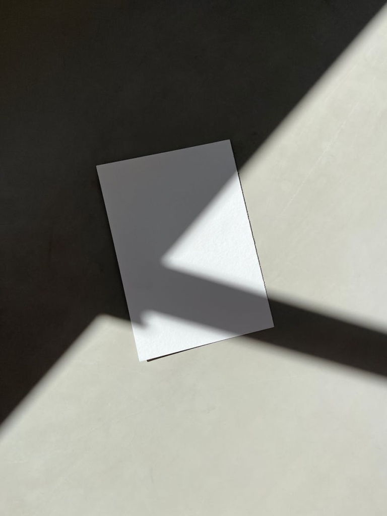 Imagen minimalista de un papel en blanco con un juego de sombras único, perfecto para maquetas de diseño.